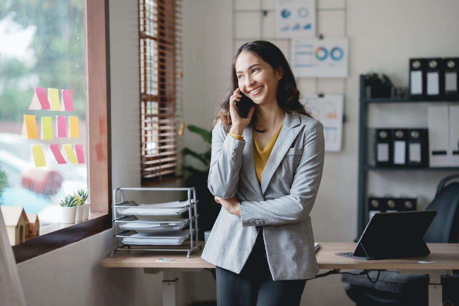 Asian businesswoman, real estate agent, talking on the phone with a customer about the detail