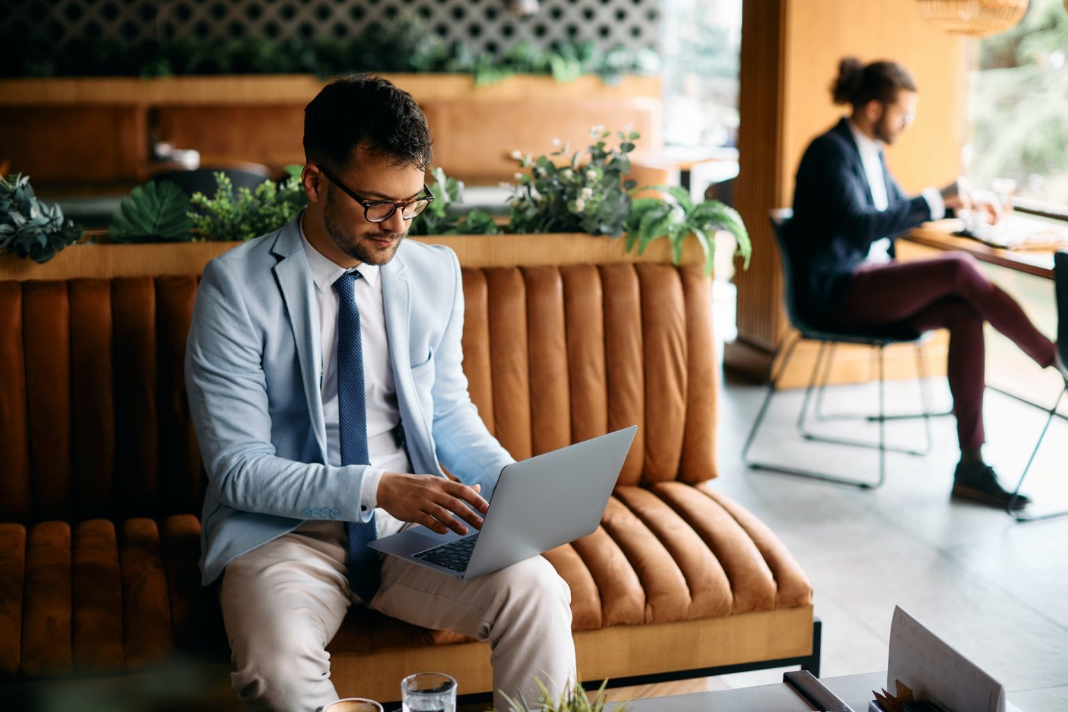 Pensive businessman reading an e-mail on laptop in a cafe.