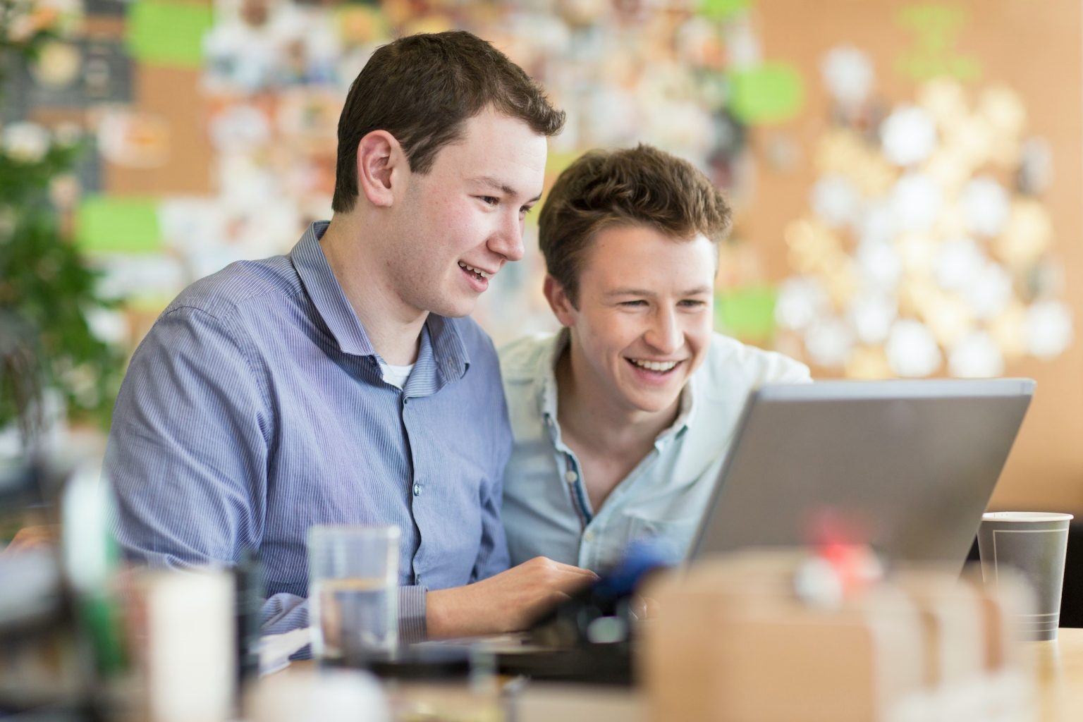 Young men working on laptop in creative office